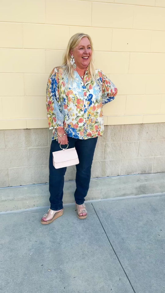 Floral chiffon blouse with frilled neckline, button front, dolman sleeves, and lightweight, flowy fit.