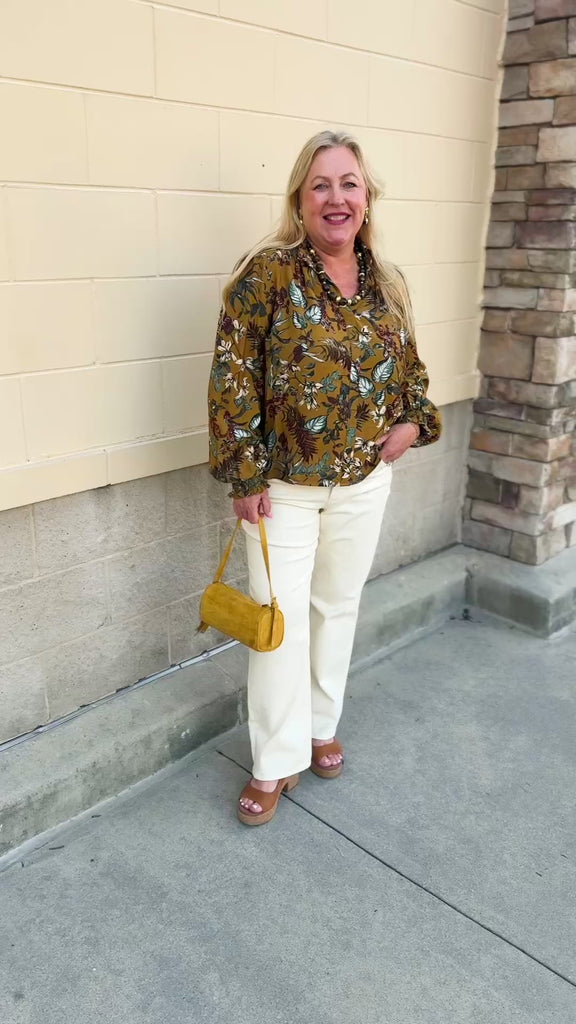 Cider-colored long-sleeve blouse with detailed leafy pattern, ruffled collar, V-neckline, and gathered sleeve cuffs