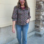 Blooming Trellis Blouse featuring a dark green background, pink diamond pattern with floral details, pink buttons, and long sleeves.