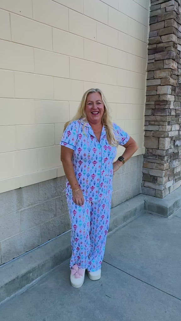 Whimsical Wonders Pajama Set featuring a short-sleeve collared top and matching long pants with colorful Christmas ornaments on a white background