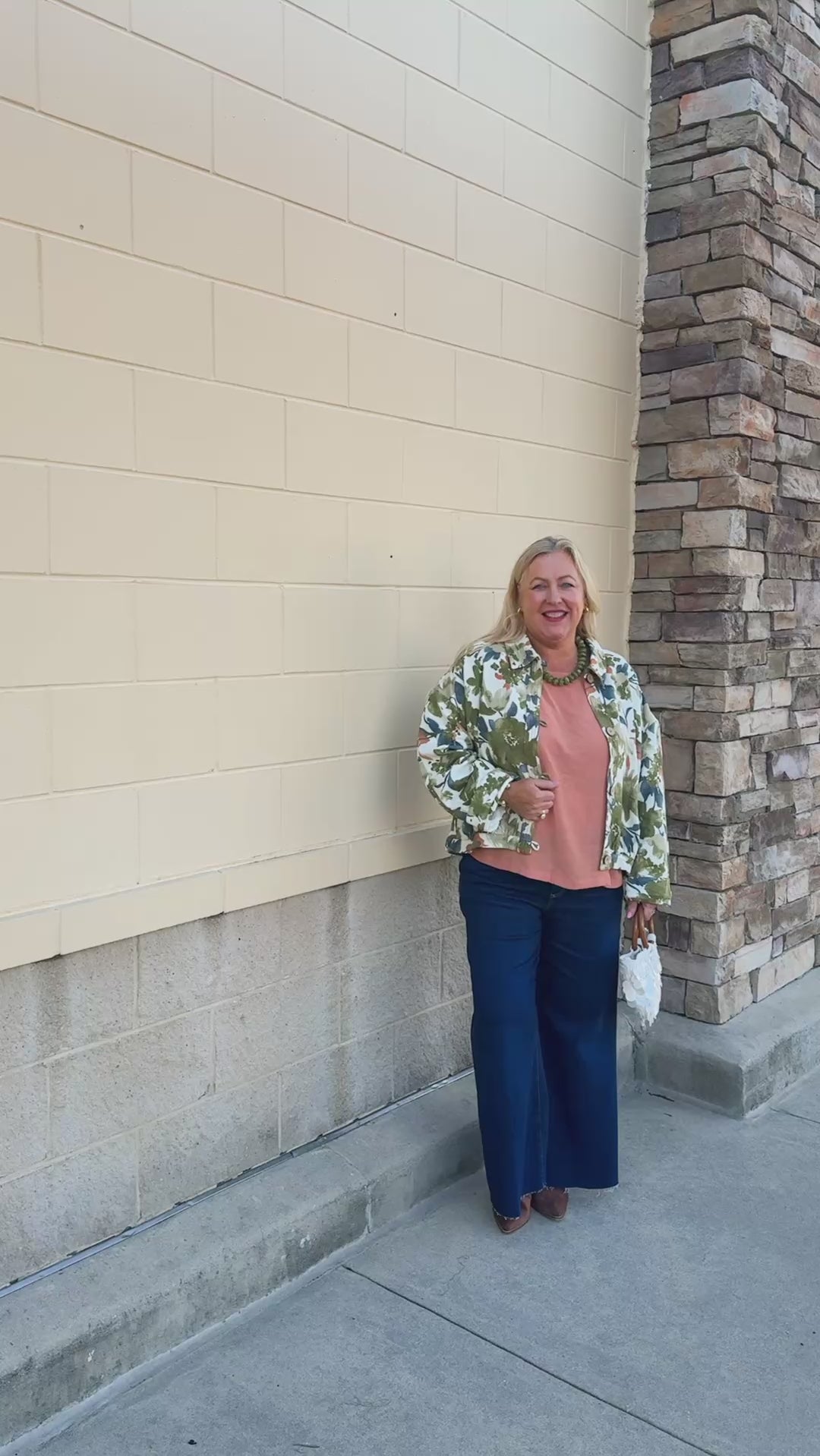 Painted Woodland Jacket featuring an olive, green, blue, and orange botanical print on a white background, a collared neckline, loop button closures, long sleeves, side pockets, and a cropped boxy silhouette.