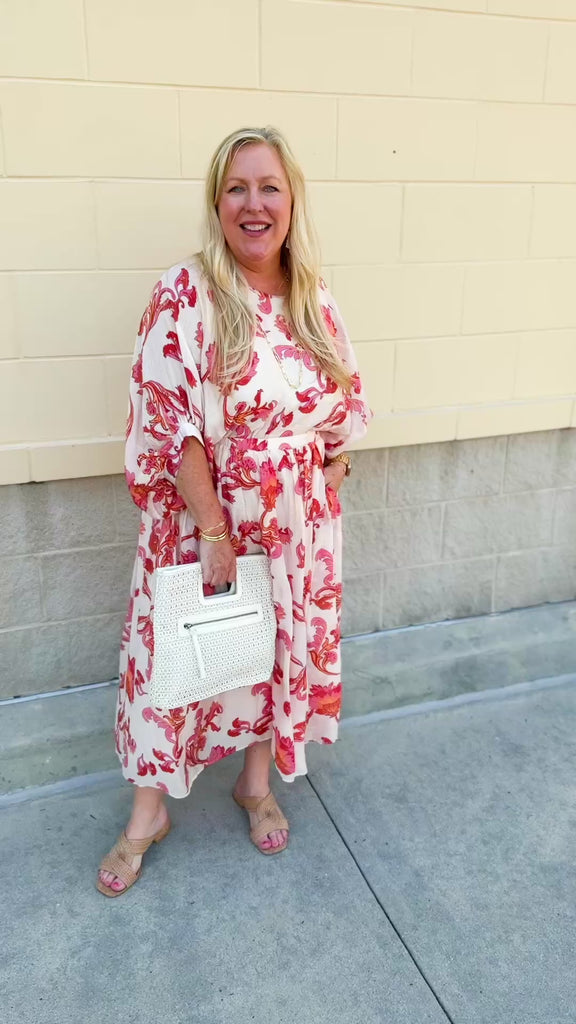 Cream midi dress with pink and orange floral print, scoop neckline, elastic waist, and flowy dolman sleeves.