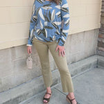 Sky blue long-sleeve top featuring white and black leaf designs.