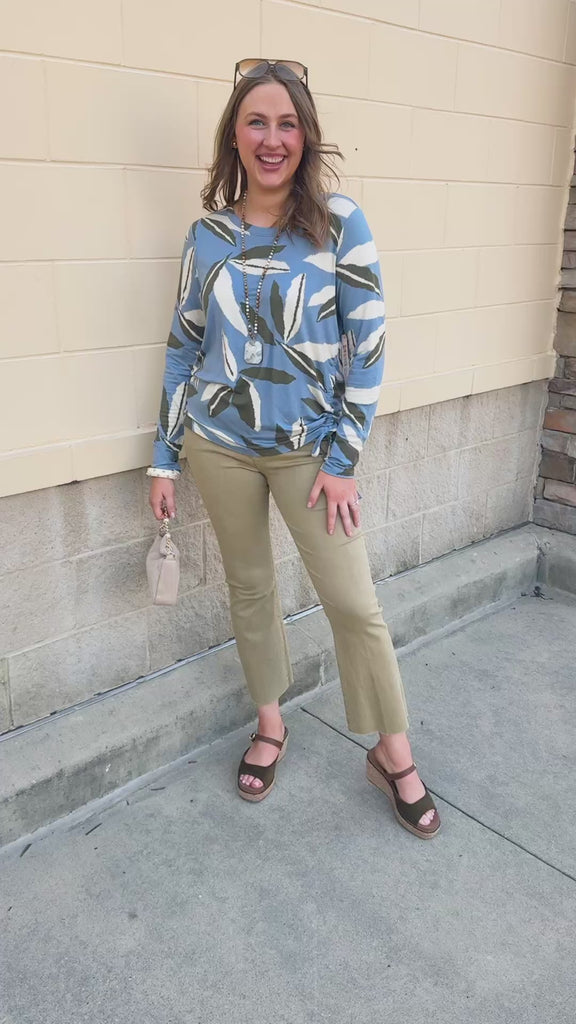 Sky blue long-sleeve top featuring white and black leaf designs.