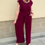Garnet short-sleeve jumpsuit with elastic waist, front tie, high scoop neckline, and side pockets. Sporty, flattering, and perfect for Gameday style.