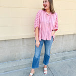 Oversized pink striped cotton gauze blouse with collar, button-down front, drop shoulders, and half sleeves.