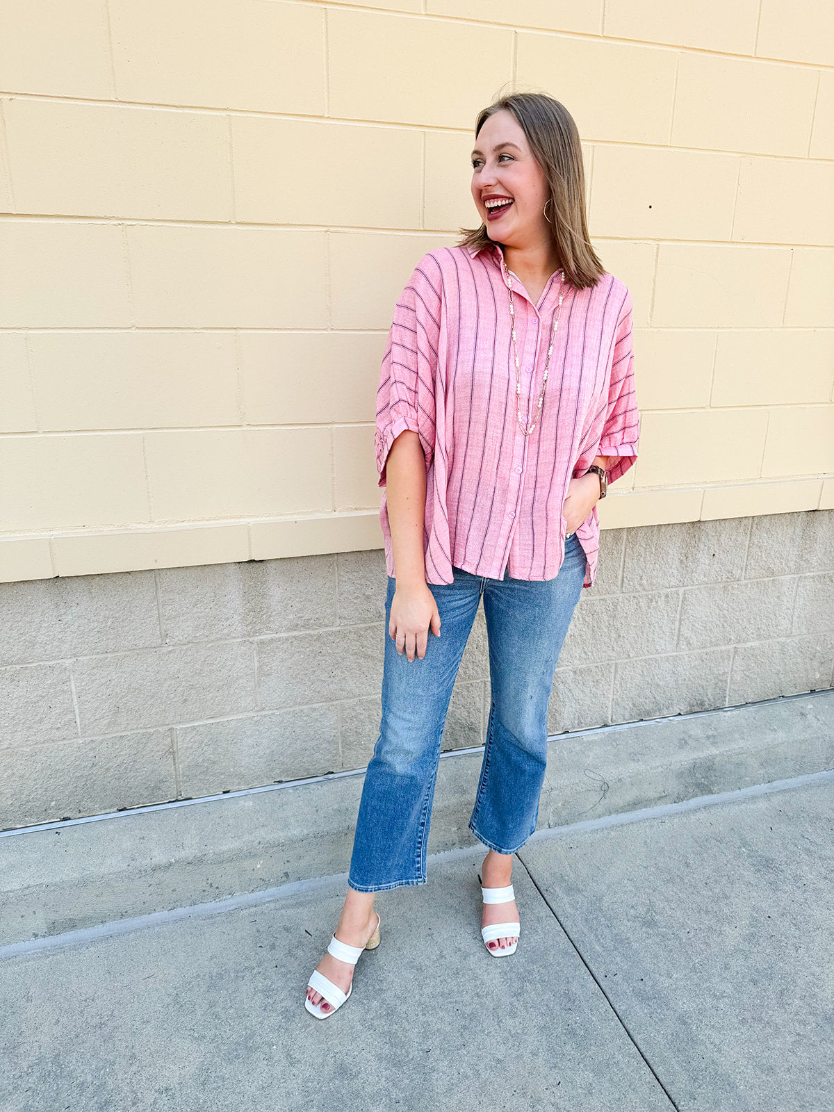Oversized pink striped cotton gauze blouse with collar, button-down front, drop shoulders, and half sleeves.