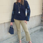 Navy blue sweatshirt with oversized light blue and white embroidered flowers covering both sleeves