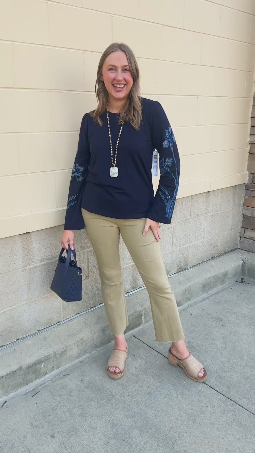 Navy blue sweatshirt with oversized light blue and white embroidered flowers covering both sleeves