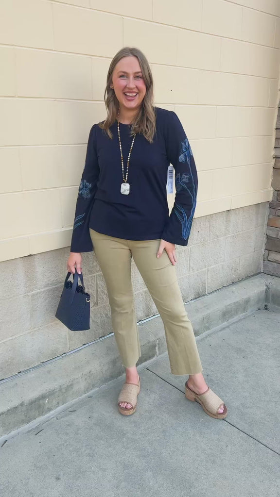 Navy blue sweatshirt with oversized light blue and white embroidered flowers covering both sleeves