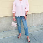 Blush blouse with V-neckline, balloon sleeves, front pleat, and ruffle-trimmed cuffs