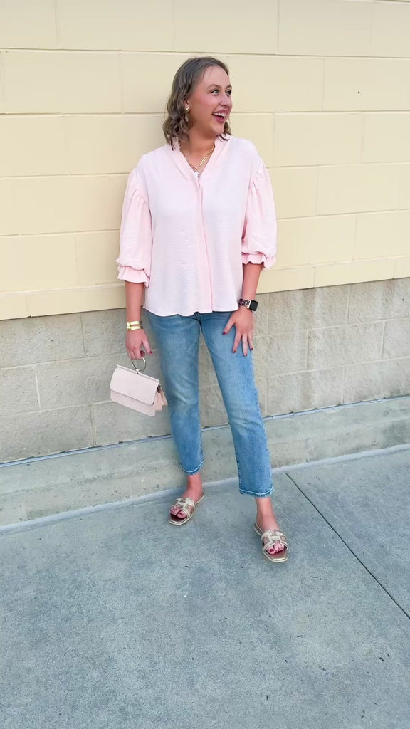 Blush blouse with V-neckline, balloon sleeves, front pleat, and ruffle-trimmed cuffs