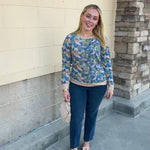 Harvest Bloom Floral Top with a taupe background, long sleeves, and blue, green, yellow, and orange flowers