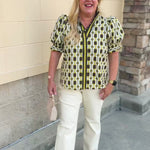 Dark green short sleeve blouse with ruffled sleeves, ruffled collar, V-neckline, chain pattern, and striped front detail