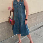 Sleeveless denim mini dress with a fold-over collar, full button-front closure, and two front pockets.