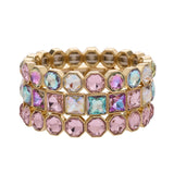 Three gold-tone bracelets with blush pink and iridescent crystals