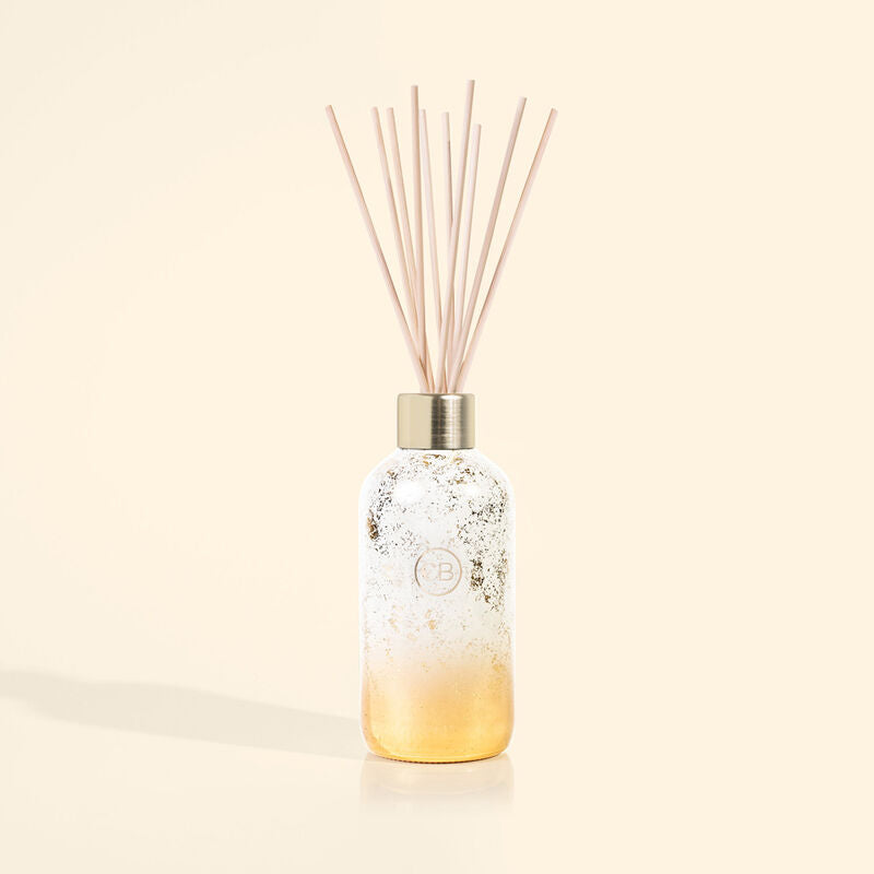 White and gold holiday reed diffuser with reeds